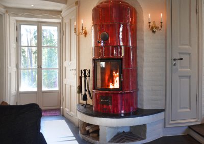 Wine-red tiled stove, created for a low energy house