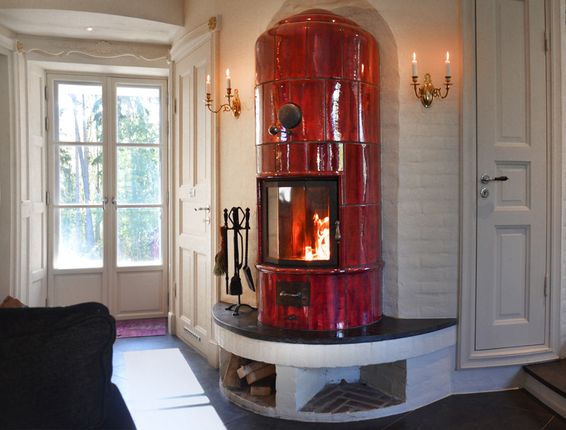 Wine-red tiled stove, created for a low energy house